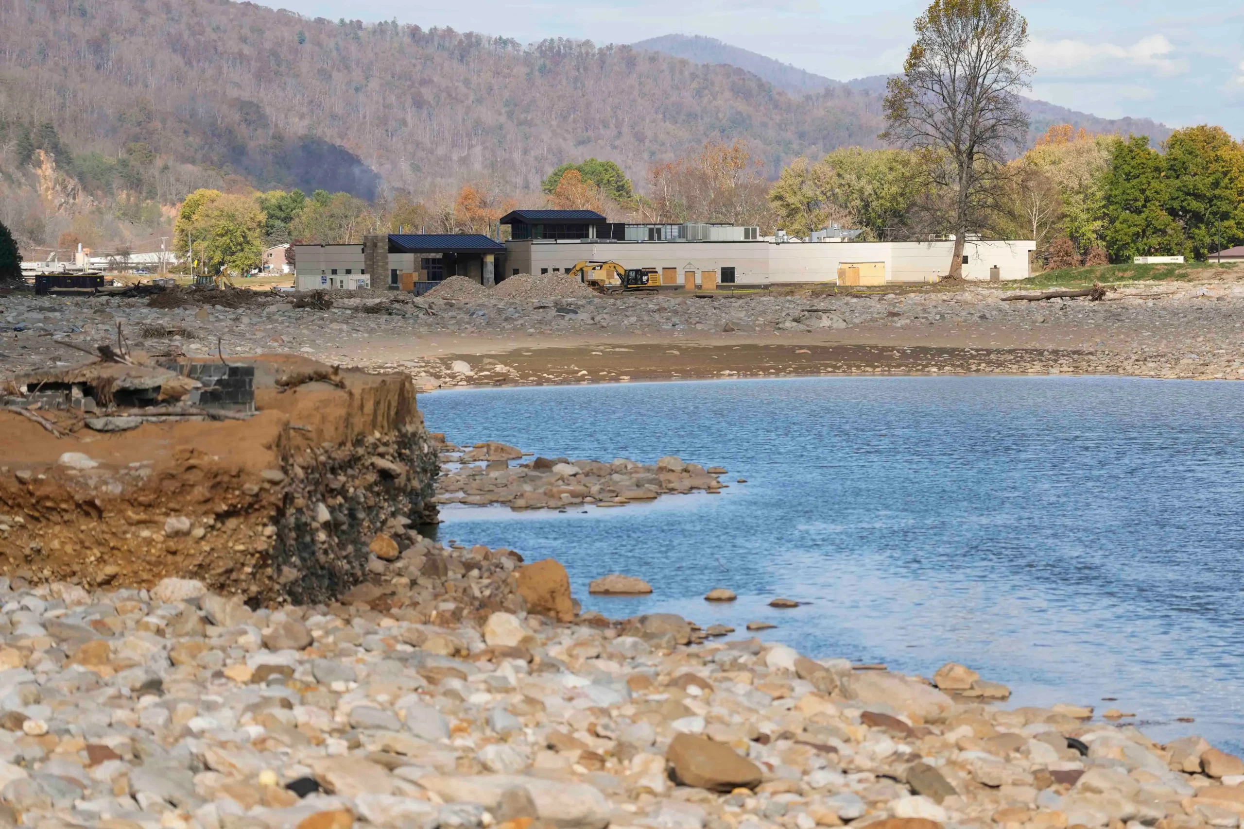 Kayakers on the Nolichucky River with forested mountains in the background near Erwin, Tennessee.